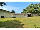Home exterior with a well-maintained lawn, mature trees, and outdoor storage at 3212 Cork Rd, Plant City, FL 33565