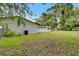 Spacious backyard with a brick house, mature trees, and an AC unit at 3212 Cork Rd, Plant City, FL 33565