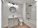 Modern bathroom featuring new vanity, tub/shower with rainfall head, round mirror and stylish lighting at 3212 Cork Rd, Plant City, FL 33565