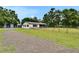 Landscaped exterior view of a well-maintained single-story home behind a fence at 3212 Cork Rd, Plant City, FL 33565