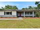Charming single-story home features a covered porch, red front door, and landscaped front yard at 3212 Cork Rd, Plant City, FL 33565