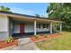 Charming single-story home features a covered porch, red front door, and landscaped front yard at 3212 Cork Rd, Plant City, FL 33565