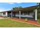 Charming single-story home features a covered porch, red front door, and landscaped front yard at 3212 Cork Rd, Plant City, FL 33565
