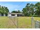 Charming single-story home featuring a cozy front porch and a spacious, well-maintained lawn with chain-link fence at 3212 Cork Rd, Plant City, FL 33565