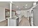 An open-concept kitchen boasts stainless steel appliances, marble countertops, white cabinets, and a kitchen island at 3212 Cork Rd, Plant City, FL 33565