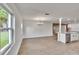 Bright, spacious living room with large windows, light wood flooring and an open view to the kitchen at 3212 Cork Rd, Plant City, FL 33565