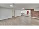 Spacious room with light wood flooring, a brick accent wall, and doorways to other rooms at 3212 Cork Rd, Plant City, FL 33565