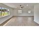 Bright living room features new floors, fresh paint, a ceiling fan and large windows at 3212 Cork Rd, Plant City, FL 33565