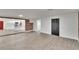 Open-concept living room with a dark door, brick accent wall and white kitchen in the background at 3212 Cork Rd, Plant City, FL 33565