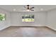 Spacious living room featuring wood-look floors, ceiling fan, and bright windows at 3212 Cork Rd, Plant City, FL 33565