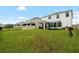 Large backyard featuring a lush lawn, trampoline, and a covered patio area at 33675 Elm Hill Br, Wesley Chapel, FL 33545