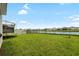 Spacious backyard with lush lawn, pond view, and a trampoline at 33675 Elm Hill Br, Wesley Chapel, FL 33545