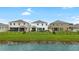 Water view from backyards of several homes with lush green grass and fencing at 33675 Elm Hill Br, Wesley Chapel, FL 33545
