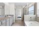 Modern bathroom showcasing granite countertops, dual sinks, and a glass-enclosed shower and tub combination at 33675 Elm Hill Br, Wesley Chapel, FL 33545