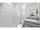 Clean bathroom featuring a walk-in shower, granite countertop, and sink, with an open view to the kitchen at 33675 Elm Hill Br, Wesley Chapel, FL 33545