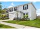Beautiful two-story home featuring black shutters, fresh landscaping, and a two-car garage at 33675 Elm Hill Br, Wesley Chapel, FL 33545