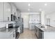 A view of the kitchen with stainless appliances, granite countertops, and light gray cabinets at 33675 Elm Hill Br, Wesley Chapel, FL 33545