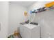 Well-lit laundry room featuring a modern washer and dryer, and storage shelving at 33675 Elm Hill Br, Wesley Chapel, FL 33545