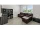 Comfortable living area featuring a plush leather recliner sofa, workstation, and tile flooring at 33675 Elm Hill Br, Wesley Chapel, FL 33545