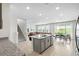 Open floor plan showing a large kitchen island, dining area, living room, and staircase at 33675 Elm Hill Br, Wesley Chapel, FL 33545