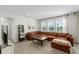 View of the living room showing a large leather sectional and bright natural light at 33675 Elm Hill Br, Wesley Chapel, FL 33545