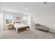 Main bedroom with carpet, a chaise lounge, and lake views from the two windows at 33675 Elm Hill Br, Wesley Chapel, FL 33545