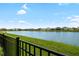 Scenic view of the pond from the backyard with a black metal fence at 33675 Elm Hill Br, Wesley Chapel, FL 33545