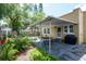 Landscaped backyard with a covered patio area, outdoor seating, and lush greenery at 3611 W Bay To Bay Blvd, Tampa, FL 33611