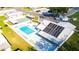Aerial view showcasing the community pool, hot tub, shuffleboard courts, and solar panels at 36435 Bonney Dr, Zephyrhills, FL 33541