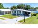 Landscaped home featuring covered parking, a well-maintained lawn, and close proximity to neighboring homes at 36435 Bonney Dr, Zephyrhills, FL 33541