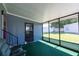 Enclosed porch with green carpet and large windows overlooking the yard at 36435 Bonney Dr, Zephyrhills, FL 33541