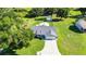 Drone shot of home with spacious driveway, well-manicured lawn, and mature shade trees at 37113 Waldo Dr, Dade City, FL 33525