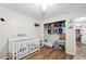 Cozy bedroom featuring a crib, open closet, and wood-look flooring at 37113 Waldo Dr, Dade City, FL 33525