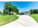 Exterior front view of home with long driveway, attached garage and American flag at 37113 Waldo Dr, Dade City, FL 33525