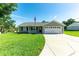 Charming single-story home with a well-manicured lawn, attached two-car garage, and a welcoming front porch at 37113 Waldo Dr, Dade City, FL 33525