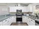Updated kitchen showcasing stainless steel appliances, white cabinetry, and modern countertops at 37113 Waldo Dr, Dade City, FL 33525