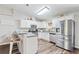 Bright kitchen featuring white cabinets, stainless steel appliances, and a breakfast bar with seating at 37113 Waldo Dr, Dade City, FL 33525