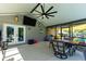Covered outdoor patio with a dining table, TV, and view of the pool at 37113 Waldo Dr, Dade City, FL 33525