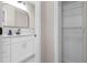 Bathroom with a white vanity, quartz countertop, black fixtures, and a view into a closet at 3907 W Walnut St, Tampa, FL 33607