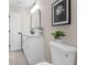 A well-lit bathroom with a white vanity, quartz countertop, modern black fixtures, and a decorative mirror at 3907 W Walnut St, Tampa, FL 33607