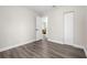 Bedroom showcasing gray wood-look flooring, white walls, closet, and an open doorway at 3907 W Walnut St, Tampa, FL 33607