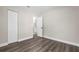 Empty bedroom with wood-look floors, light walls, closet and view of the ensuite bathroom at 3907 W Walnut St, Tampa, FL 33607