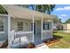 Close-up of the covered front porch with white railings and a view of the well-kept front yard at 3907 W Walnut St, Tampa, FL 33607