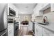 Bright kitchen featuring stainless steel appliances, white cabinetry, and view into the living room at 3907 W Walnut St, Tampa, FL 33607