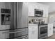 Kitchen features stainless steel fridge, microwave and oven with white cabinets and backsplash at 3907 W Walnut St, Tampa, FL 33607