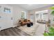 Cozy living room featuring a leather sofa, neutral rug, and ample natural light at 3907 W Walnut St, Tampa, FL 33607