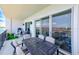 Spacious balcony with a grill and table, offering a view of the water and nearby buildings at 400 150Th Ave # 504, Madeira Beach, FL 33708