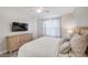 Comfortable bedroom featuring hardwood floors and a mounted TV with dresser at 400 150Th Ave # 504, Madeira Beach, FL 33708