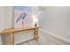 Inviting hallway with wood floors, a wooden table, and a decorative heron art piece at 400 150Th Ave # 504, Madeira Beach, FL 33708