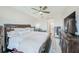 Spacious main bedroom featuring detailed wood furnishings, a ceiling fan and a view to the ensuite at 400 150Th Ave # 504, Madeira Beach, FL 33708